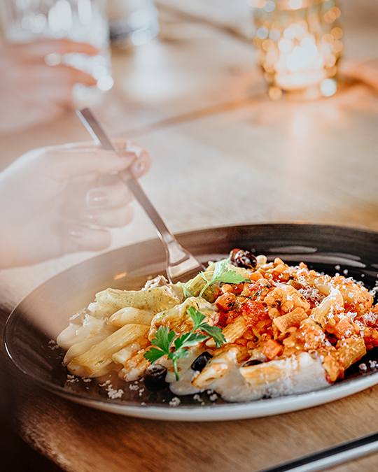 Nudeln mit zwei verschiedenen Saucen auf einem Teller 